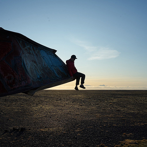 Jonathan Bell sitting on a twisted piece of metal